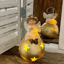 Weihnachtsengel auf beleuchteter Kugel