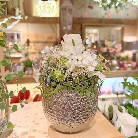 Blumenarrangement im silbernen Topf