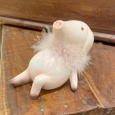 Schwein Sannie mit Federboa sitzend